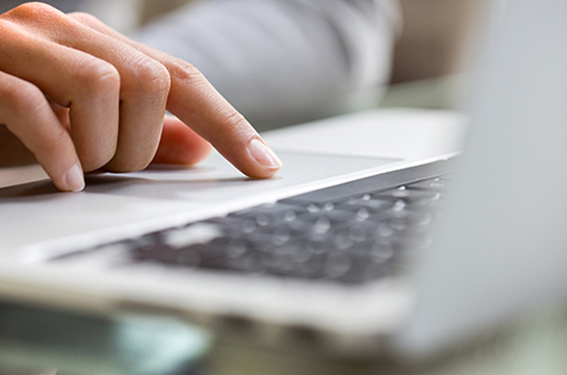 Hand using track pad on laptop