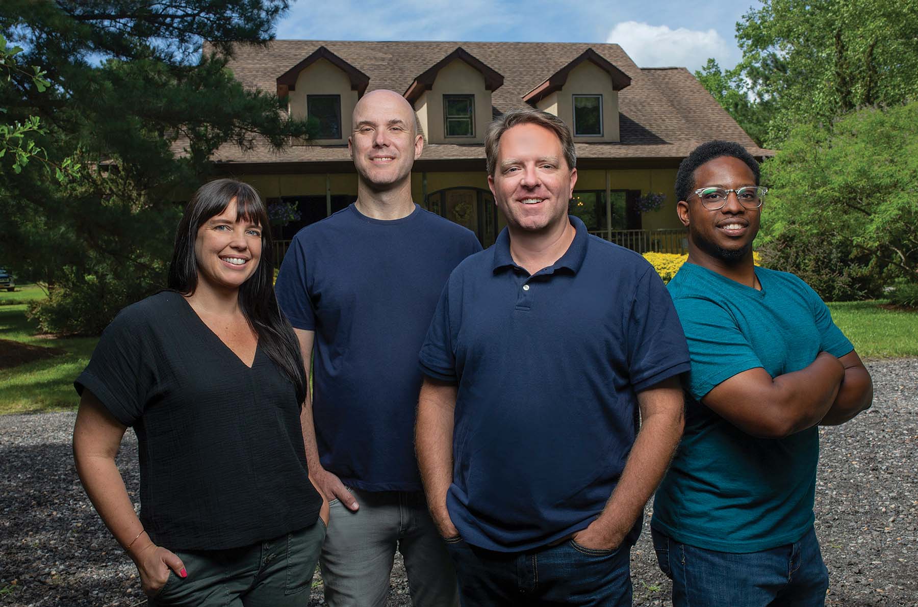 Jaime Ebanks, Mike Kelleher, Matt Paxton, and Avi Hopkins stand in front of a house