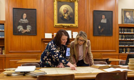 Samantha Brown and Lindsay Fulton examine a record in the American Ancestors Research Center