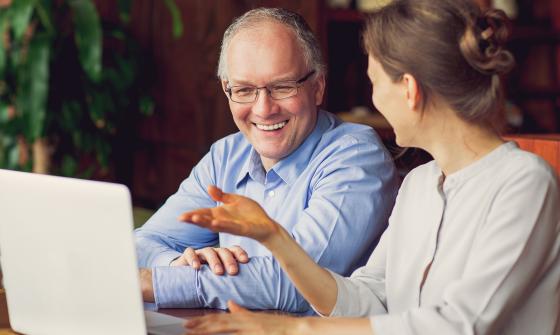 Woman showing a man a computer screen