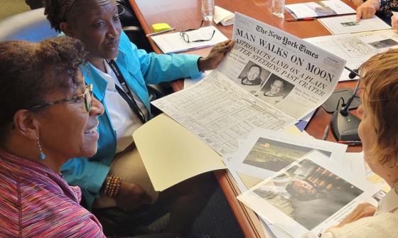 Women review a table full of documents