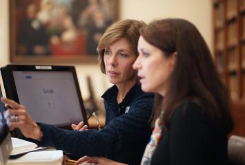 Researcher works with client at a computer