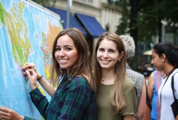 Smiling people pinning location to map