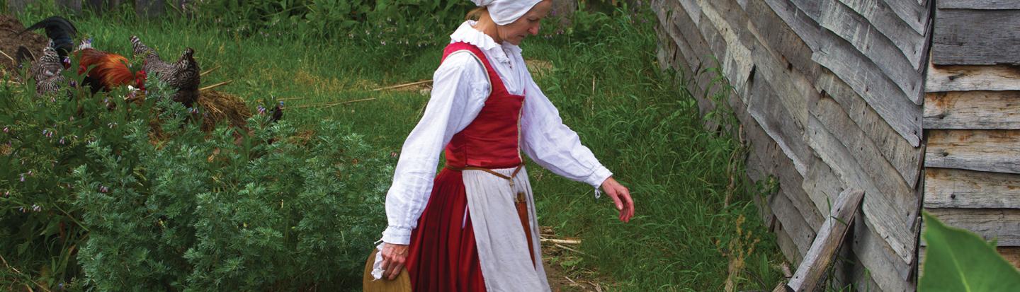 woman feeding chickens at plimouth plantation