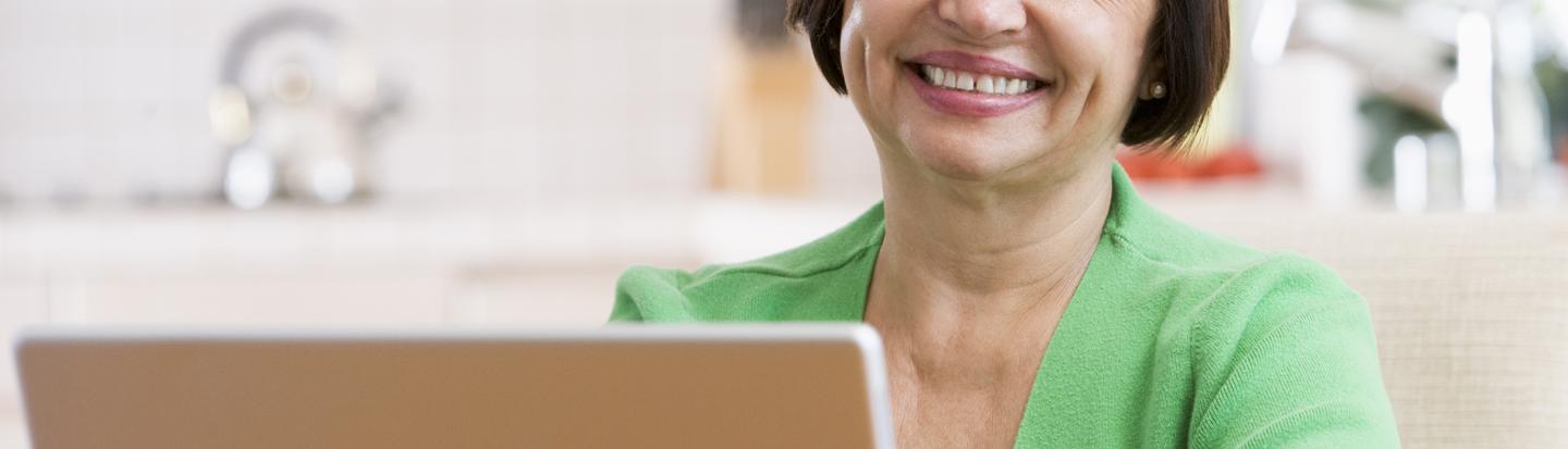 event-virtual-stay-at-home-6-2023-2.jpg woman with a green shirt on a laptop
