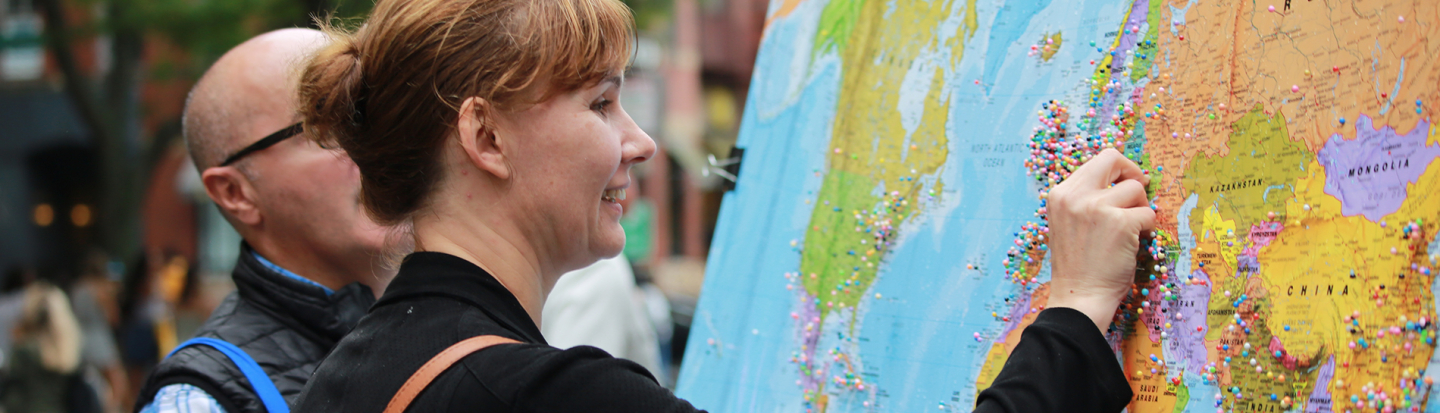 woman placing a pin in a map
