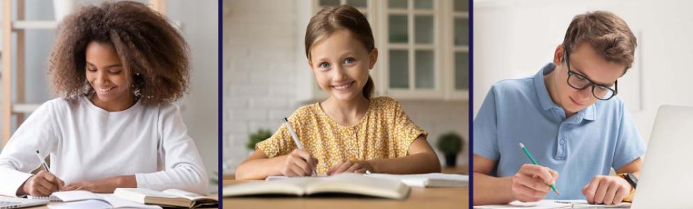 Young students seated at tables writing in notebooks