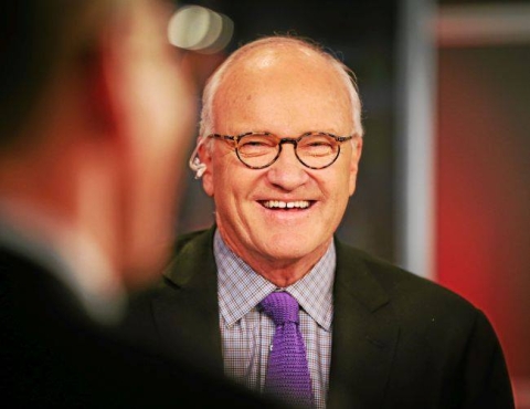 Mike Barnacle laughs in an over-the-shoulder shot of him during a recorded interview or discussion