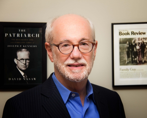 David Nasaw is photographed before a wall with the framed cover of "The Patriarch" and a review of a book of his