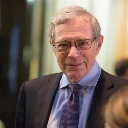 Eric Foner in suit looking into camera with blurred background
