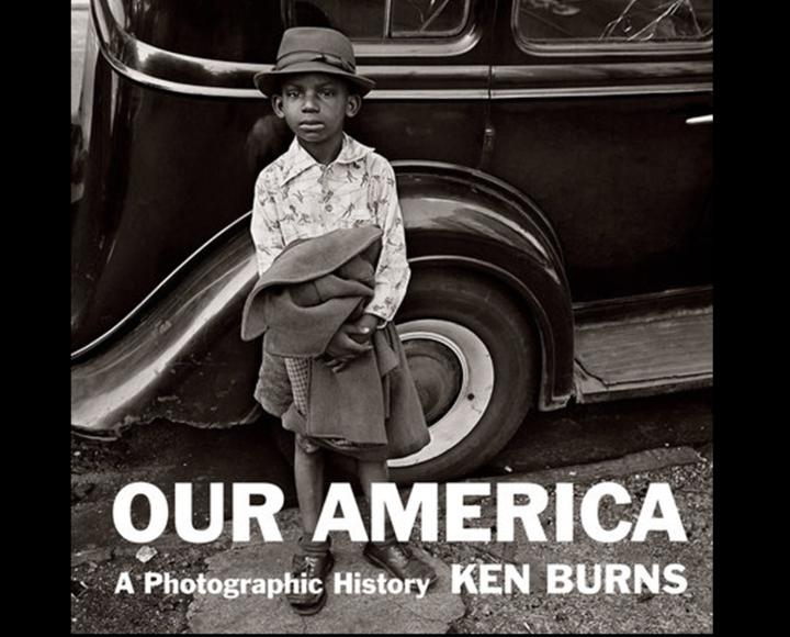 little boy standing in front of car