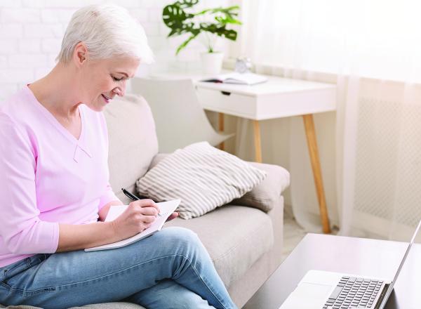 Woman taking notes from laptop