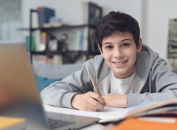 Student writing and smiling