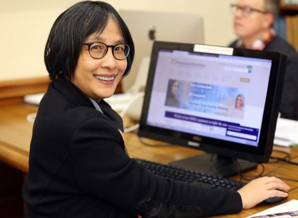 Woman sitting at computer turns to smile at camera