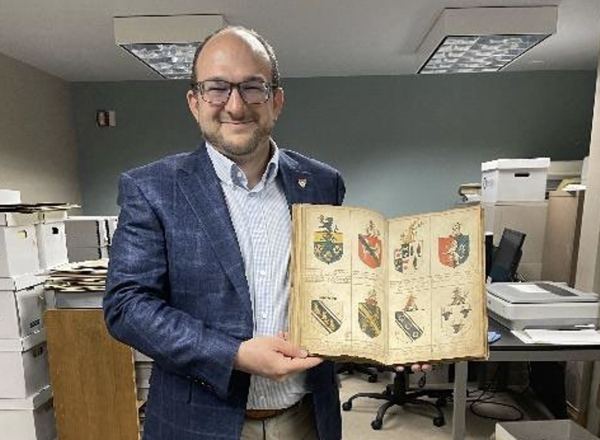 Brady Brim-DeForest, Publisher of Palfrey Press and Patron of the 36th International Congress of Genealogical and Heraldic Sciences, holds the original 1750s Gore Roll. 