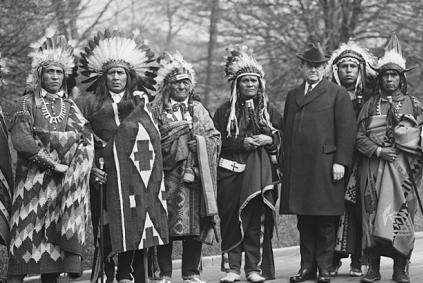 Black and white photo of a group of tribal representatives in formal dress