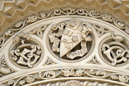 Dos and Don'ts of Designing Your Coat of Arms Stone carving on a 19th century building with coat of arms and educational heraldry and symbols