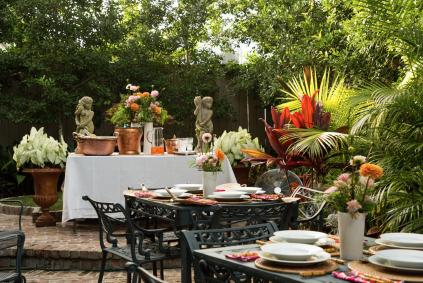 Classical Shindig: Amateur Artistry From Two New Orleans Gentlemen garden party setup with tables, plates, and flowers