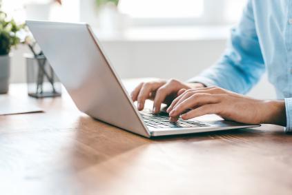 person writing on a laptop