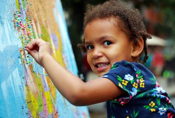 Child putting pin in a map