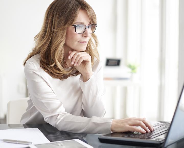 woman on computer with paperwork